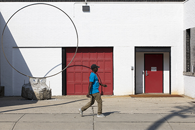 person in blue shirt in front of red door
