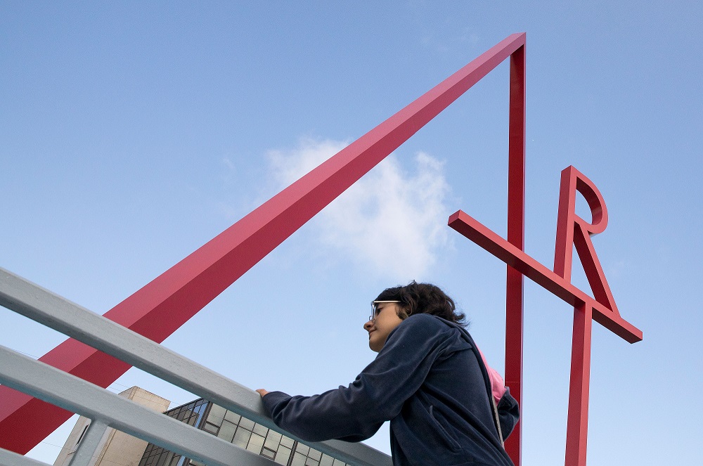 student looks down from art sign