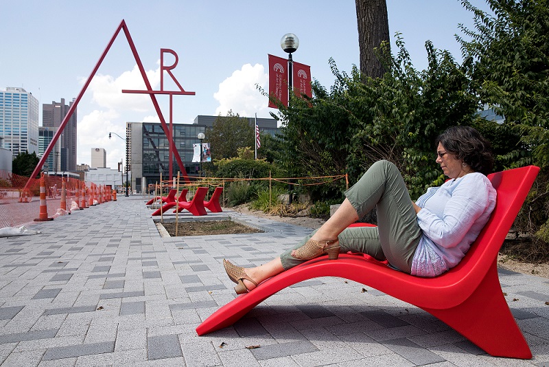 christine hill relaxes in front of art sign