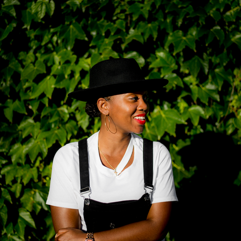 Portrait of Elyse Applewhite standing in front of foliage