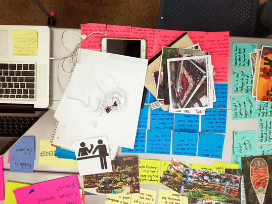 Master of Design, Overhead shot looking down on brainstorming notes, sketches, inspiration photos, and a laptop