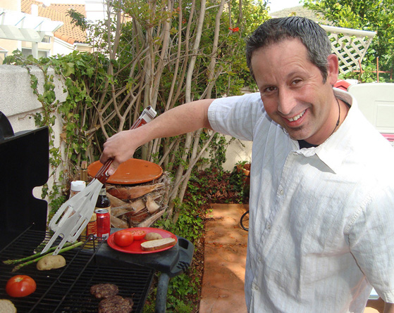 Industrial Design, Image of Peter using BBQ tool standing at grill, grilling veggies in backyard setting