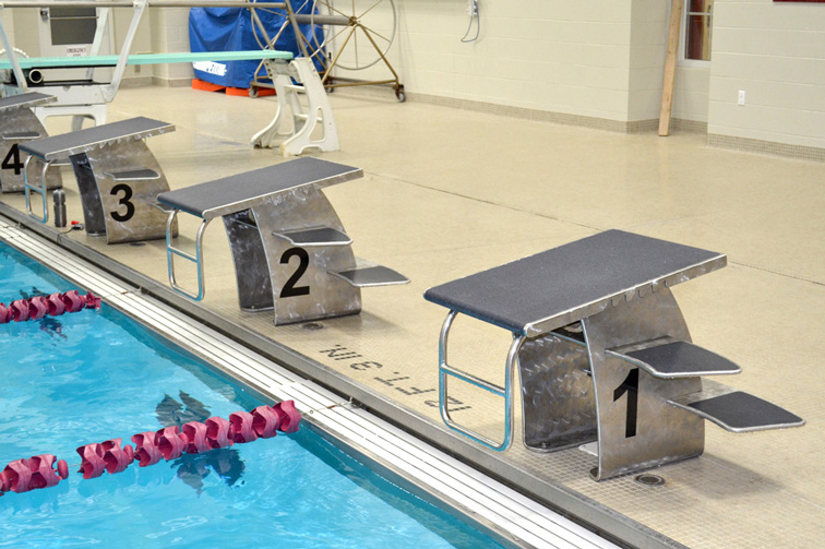 Industrial Design, Close up of starting blocks on edge of swimming pool, pool lanes divided by floating pink dividers