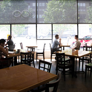 Life at CCAD, Interior shot of cafe tables with people in front of window overlooking street in Roosevelt Coffee House near CCAD