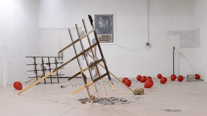 Fine Arts, Multimedia gallery installation featuring red balloons and burnt wooden scaffolding 