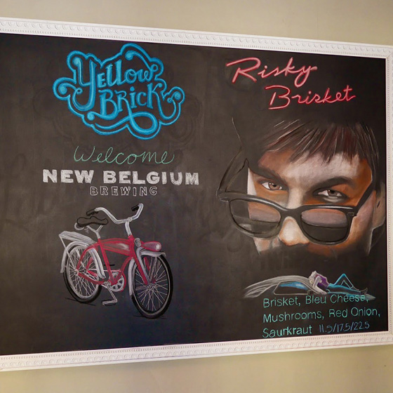 Fine Arts, Chalk Portrait of Tom Cruise for Yellow Brick Pizza next to Yellow Brick Logo and drawing of red bicycle 