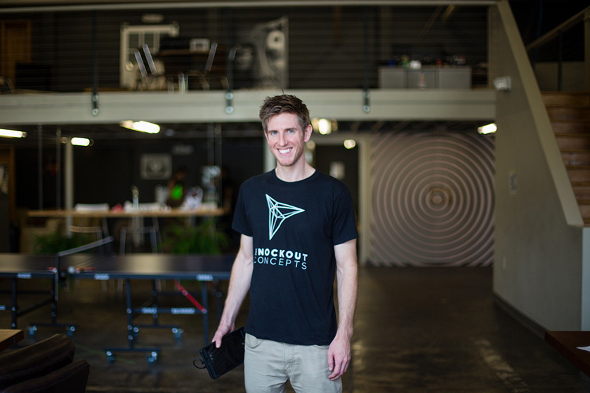 Industrial Design, Photo of Brooks Meyers from Knockout Concept in black thsirt featuring company name against blurred backdrop of industrial modern office space