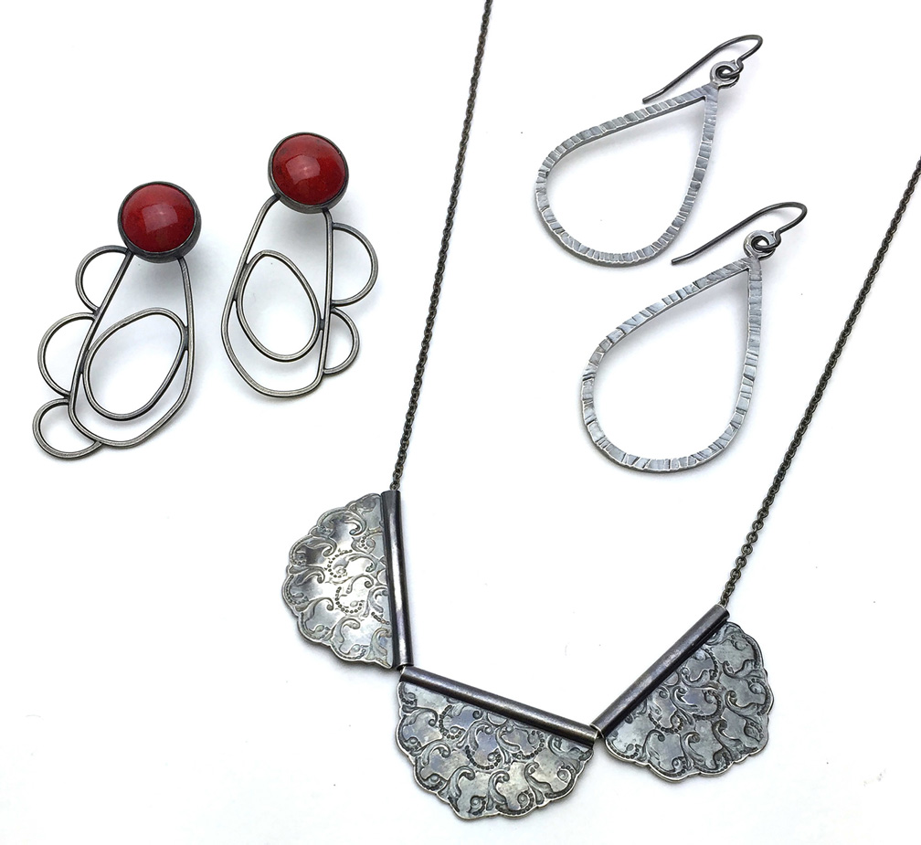 Contemporary Crafts, Image of necklace with three petal shaped pendants, pair of metal tear drop earrings, and pair of red earrings with metal petals on a white background