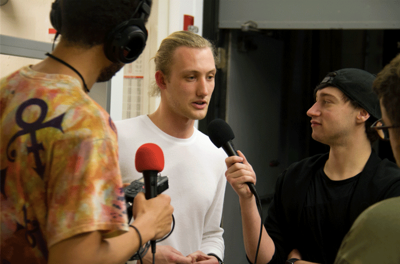 Life at CCAD, Four students from the podcast class speaking and holding microphones