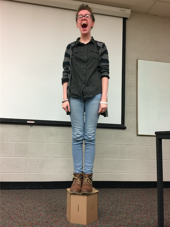 Animation, student stands on cardboard structure in classroom