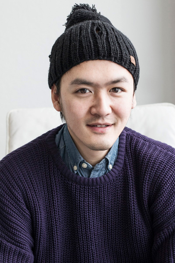 Master of Fine Arts, Portrait of CCAD MFA grad Dalong Yang in purple sweater layered over denim button up and dark gray beanie