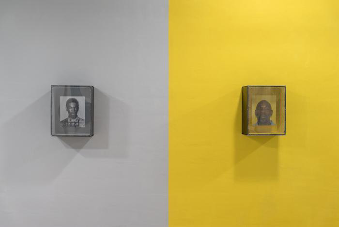 Fine Arts, Two photographs hanging on a gallery wall, to the left a black and white mug shot hangs on a gray wall, to the right a color photo of the same man hangs on a bright yellow wall