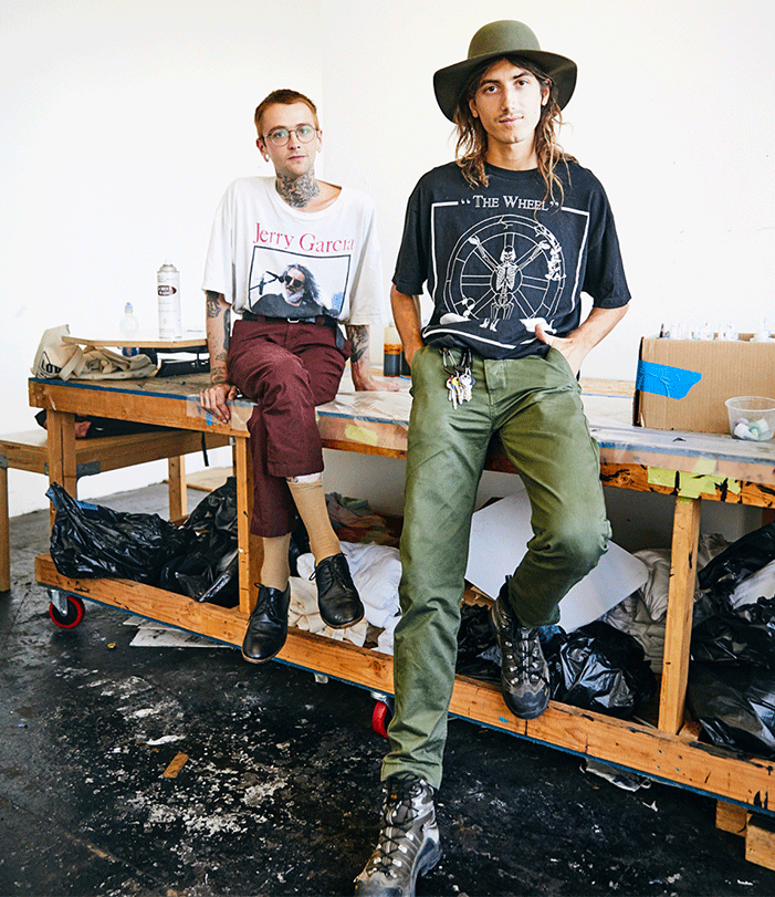 Fine Arts, Alix Ross and Elijah Funk pose for photo sitting on a workshop table