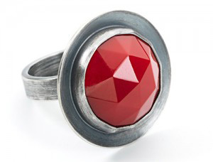 Fine Arts, Silver ring on white background with red, triangularly faceted gem