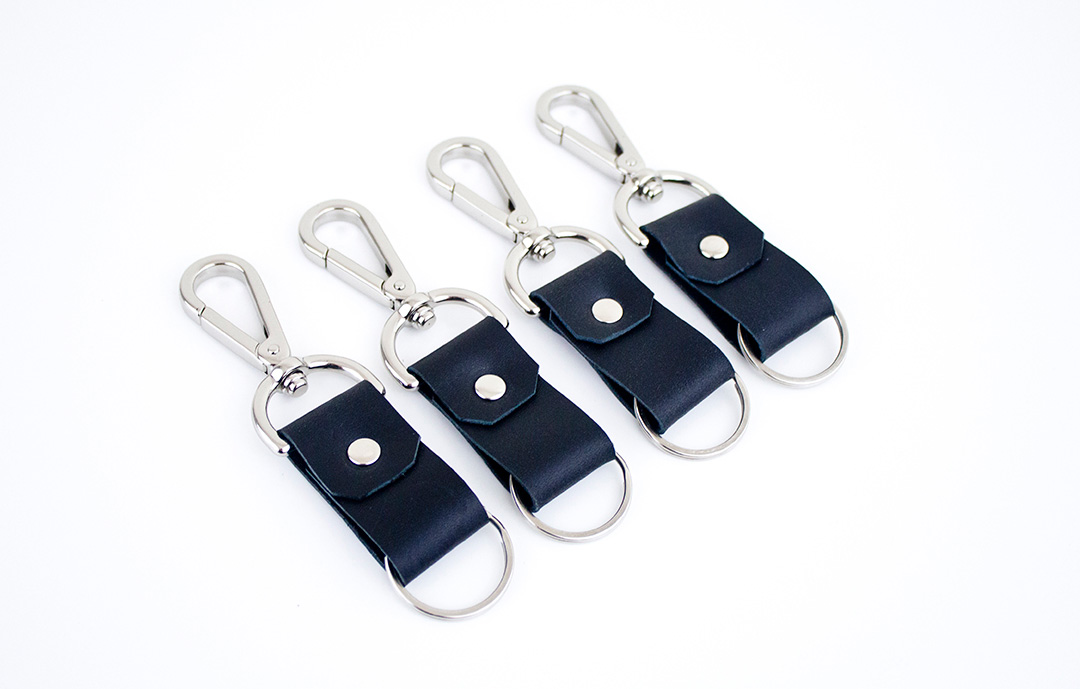 Fashion Design, Image of black of four leather key rings with silver hardware on white background