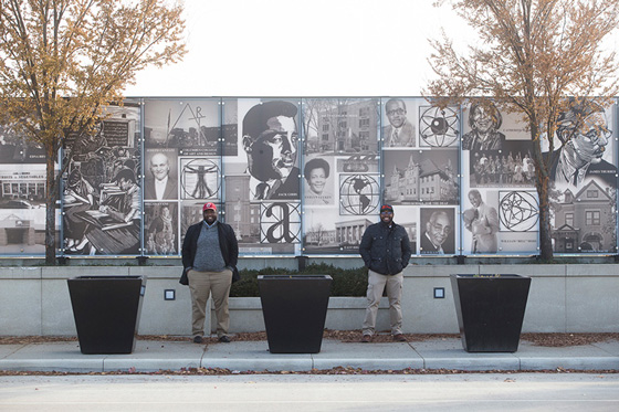 Industrial Design, Illustration, Corey and Marshall standing in front of bridge mural of black and white photos 