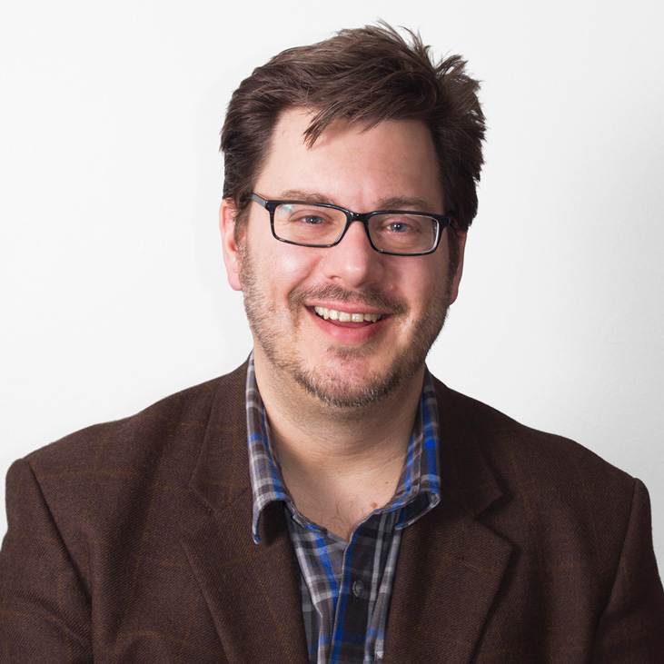 CORE, Close up of professor loss in a brown jacket against a white background