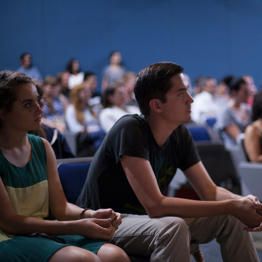 Life at CCAD, Two students lean forward in crowded auditorium seats at event for Visting Speakers at CCAD's Beeler Gallery