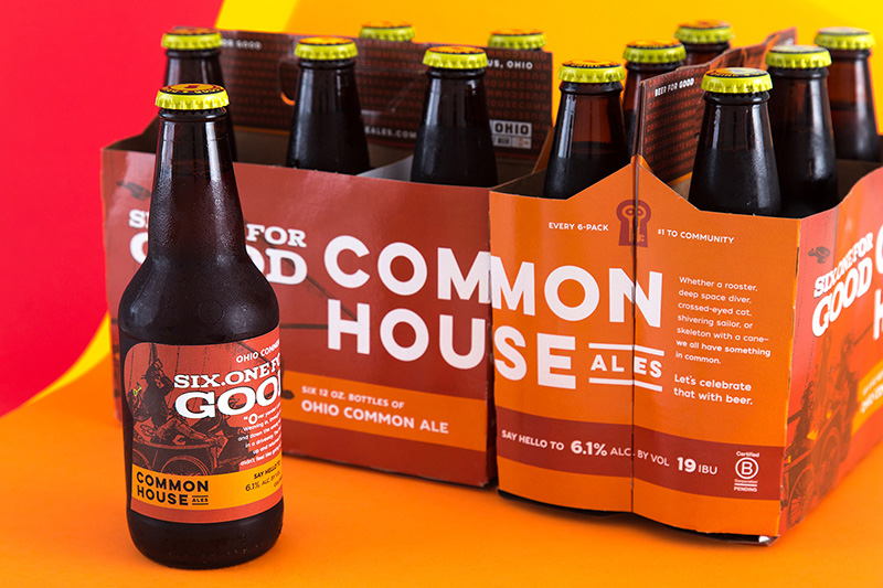 Advertising & Graphic Design, Dark brown bottle of ale with red, white, and orage label sitting in front of two six packs side by side, one red with white text and orange accents, the other orange with white text and red accents.