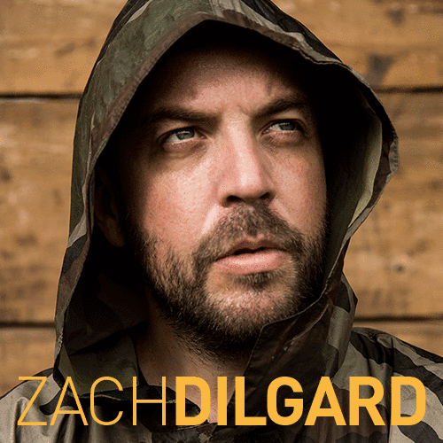 Photography, headshot of Zach wearing hooded jacket with hood up, staring slightly out beyond camera, text at bottom in gold reads "Zach Dilgard"