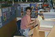 Tony smiles up at camera while working at animation desk