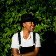 Portrait of Elyse Applewhite standing in front of foliage 