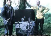 Kubrick and McCall standing on either side of movie poster, outdoors.