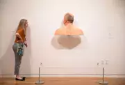 girl peeks at front of art piece