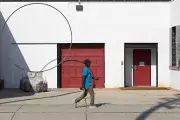 person in blue shirt in front of red door