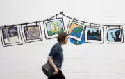 person walks past mural