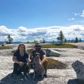 family with puppy in mountain