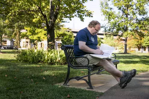 steven hubbard on bench with book