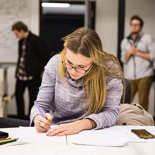 Student works at a desk in a CCAD classroom.