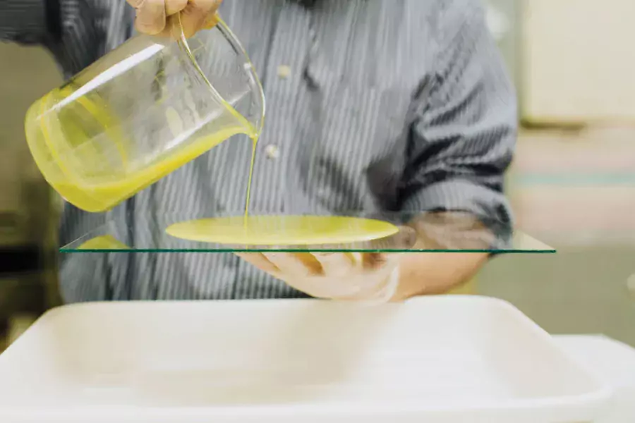 green liquid pouring on glass